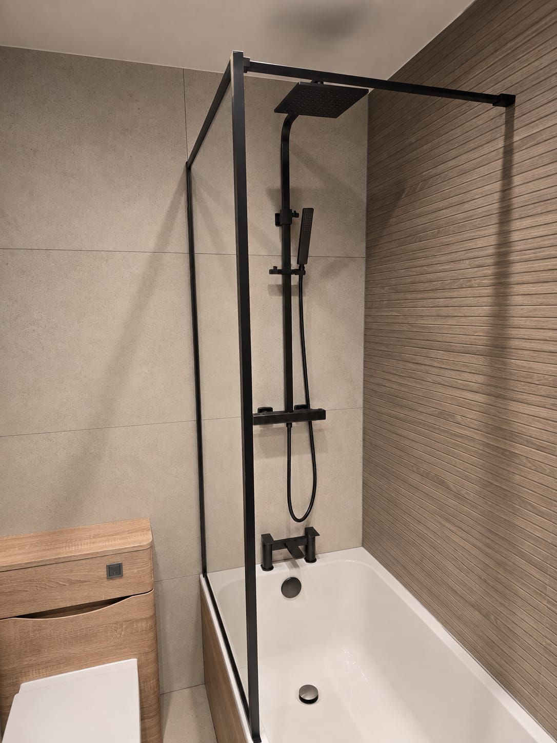 Bathroom project by Quality Life Build – Black framed bath screen and rainfall shower