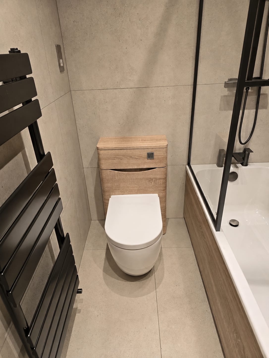 Bathroom project by Quality Life Build – Bath and WC unit with black heated towel rail